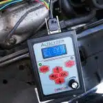 La pantalla del comprobador muestra la siguiente información: tensiones (ajustadas y medidas) y etapa de carga.